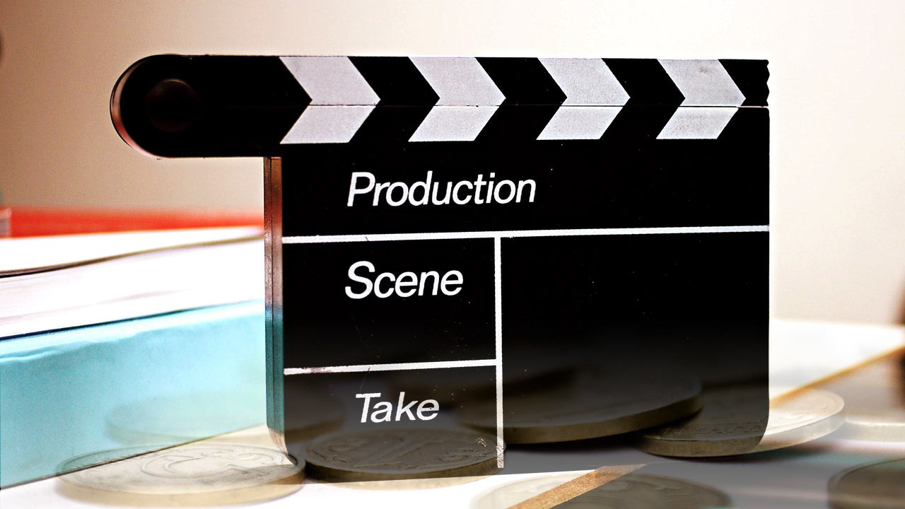 Film clapperboard and gold coins